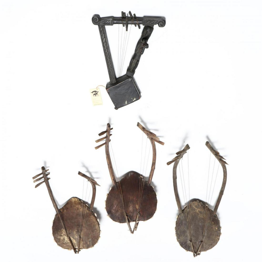 Three Kenyan Two-Armed Harps and a Small African: Three Kenyan Two-Armed Harps and a Small African Figural Harpthe two-armed harps with six strings, gourd bodies, cowhide tops and cowrie shell decoration (slightly varied sizes, 20 in. average); the s