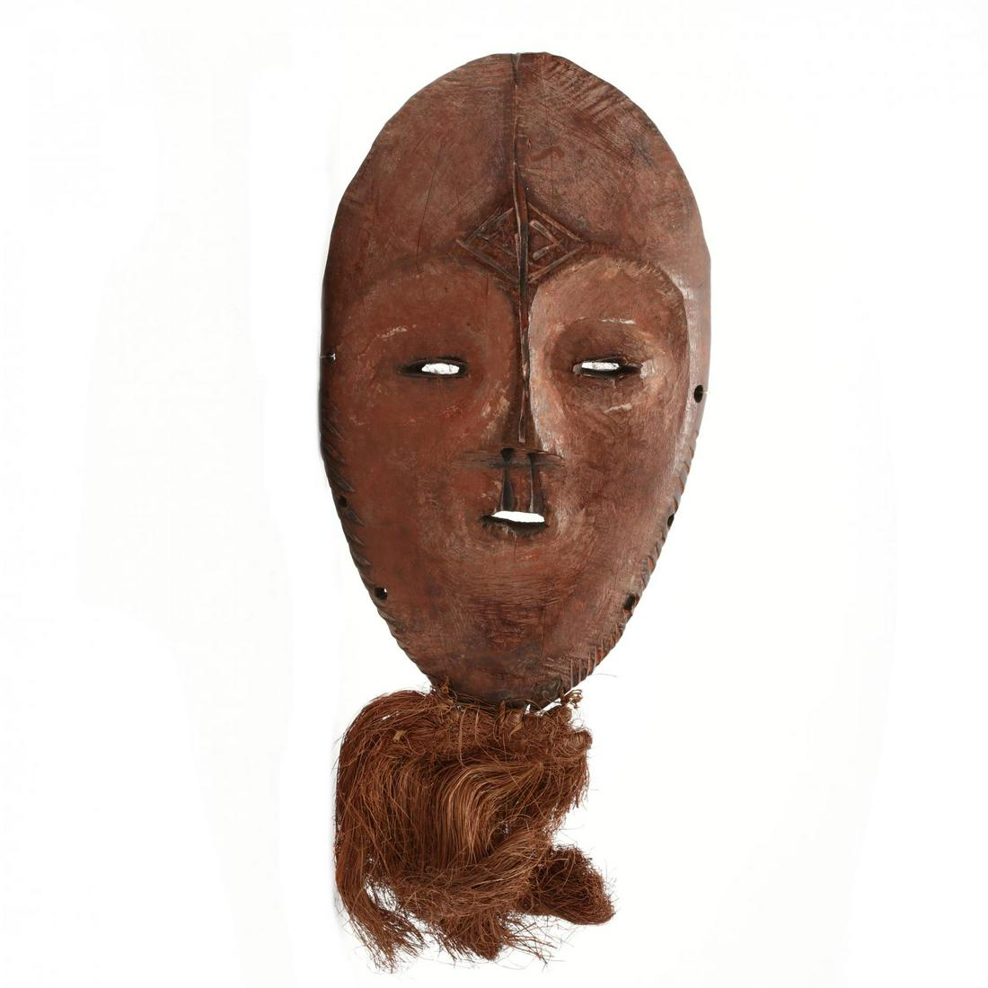 Zaire, Pende Mask: Zaire, Pende Mask carved wood with allover red pigment and applied dried grass to the chin. 8 x 5 in. Deaccessioned from the North Carolina Museum of Art and being sold to benefit the growth of the mu