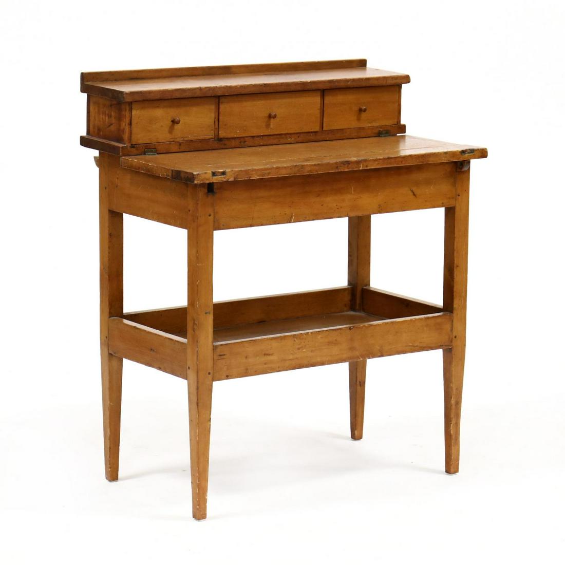 Antique Southern Child Size Work Bench: Antique Southern Child Size Work Bench yellow pine, three upper drawers above a flat work surface with lift lid for additional storage, lower gallery shelf, raised on tapered legs. 34 x 29 x 17.5 in. 