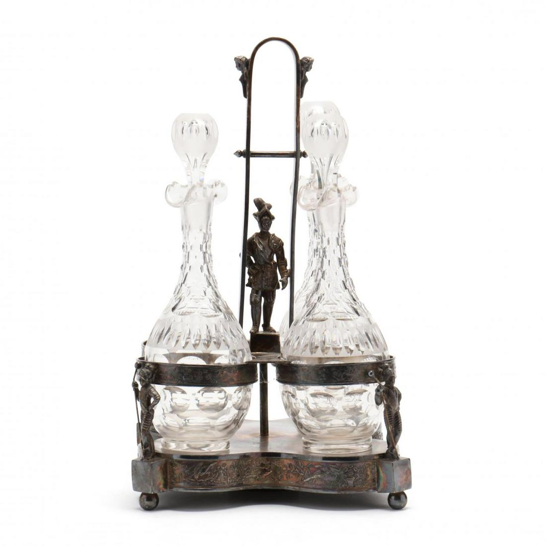 Victorian Silverplate Bottle Stand: Victorian Silverplate Bottle Stand 19th century, figural handle featuring an armored knight, four receptacles with three cut glass decanters, repeating armored figural supports, appears unmarked. Stan