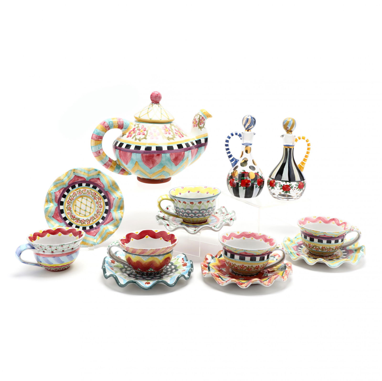 McKenzie Childs, (13) Piece Tea Set: McKenzie Childs, (13) Piece Tea SetAmerican, late 20th century, including a pair of painted glass cruets, terra-cotta teapot, (5) cups and (5) saucers, each hand decorated, marked. Teapot 9 in. Addit