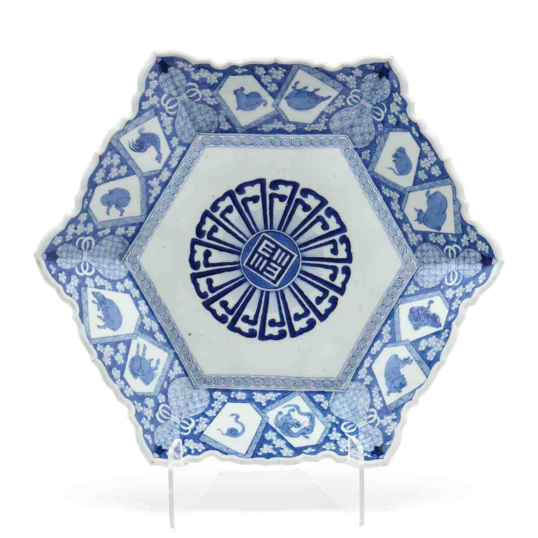 A Japanese Blue and White Charger with Zodiac Animals: A Japanese Blue and White Charger with Zodiac Animals Meiji period (1868-1912), porcelain barbed rim hexagonal shaped charger hand painted in underglaze blue with the twelve animals of the Chinese zod