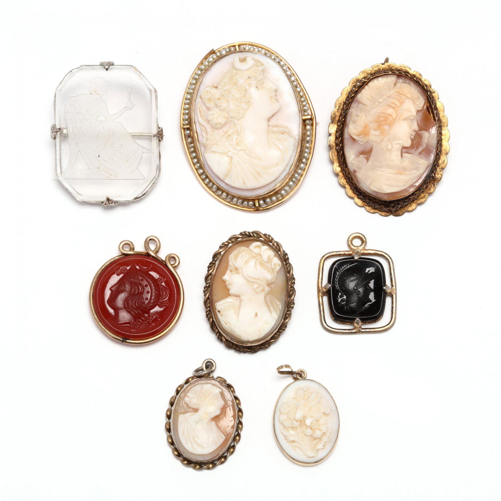 A Group of Cameo and Intaglio Jewelry Items: A Group of Cameo and Intaglio Jewelry Items to include: an oval, carved coral cameo brooch with seed pearl accents, stamped 10K (1.25 x 1.5 in.); an oval carved coral floral cameo pendant, tested 14K 