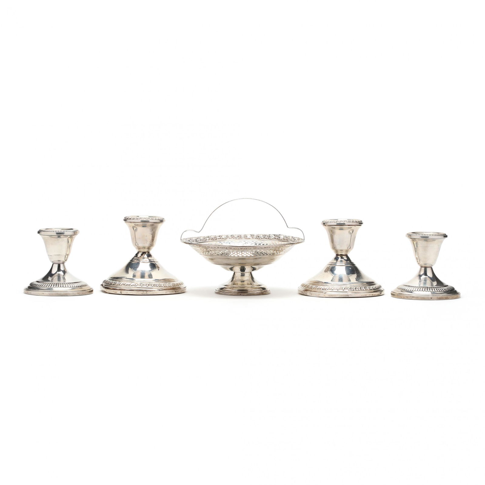 Five Sterling Silver Table Accessories: Five Sterling Silver Table Accessoriesincluding (2) pairs of low candlesticks and a handle bon bon basket, all with weighted bases, no monograms. Additional high-resolution photos are available at Le