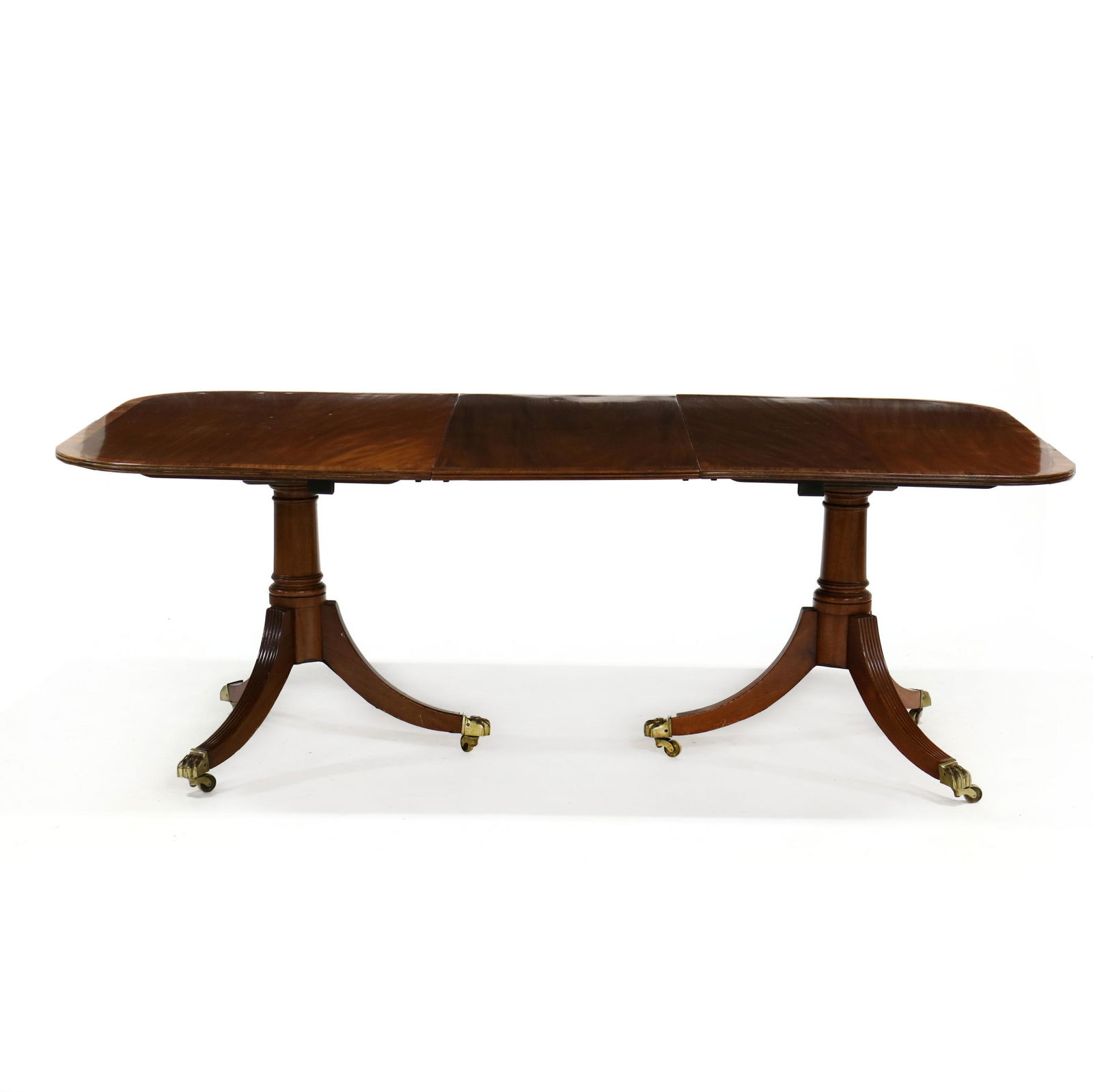 Federal Style Mahogany Double Pedestal Dining Table: Federal Style Mahogany Double Pedestal Dining Tableearly 20th century, top with reeded edge, open to accept one leaf, turned pedestals, reeded downswept legs, on brass feet and casters. 30 x44 x 79 in