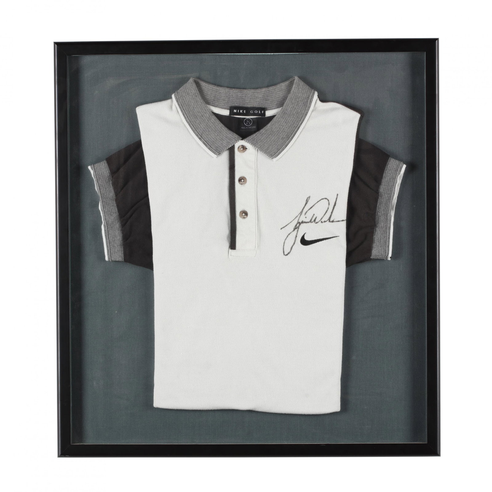 Tiger Woods Signed Nike Golf Shirt: Tiger Woods Signed Nike Golf Shirt large size, signed above Nike logo on left breast, presented in shallow shadowbox frame. This item was acquired in a silent auction at the Mia Hamm Foundation Golf C