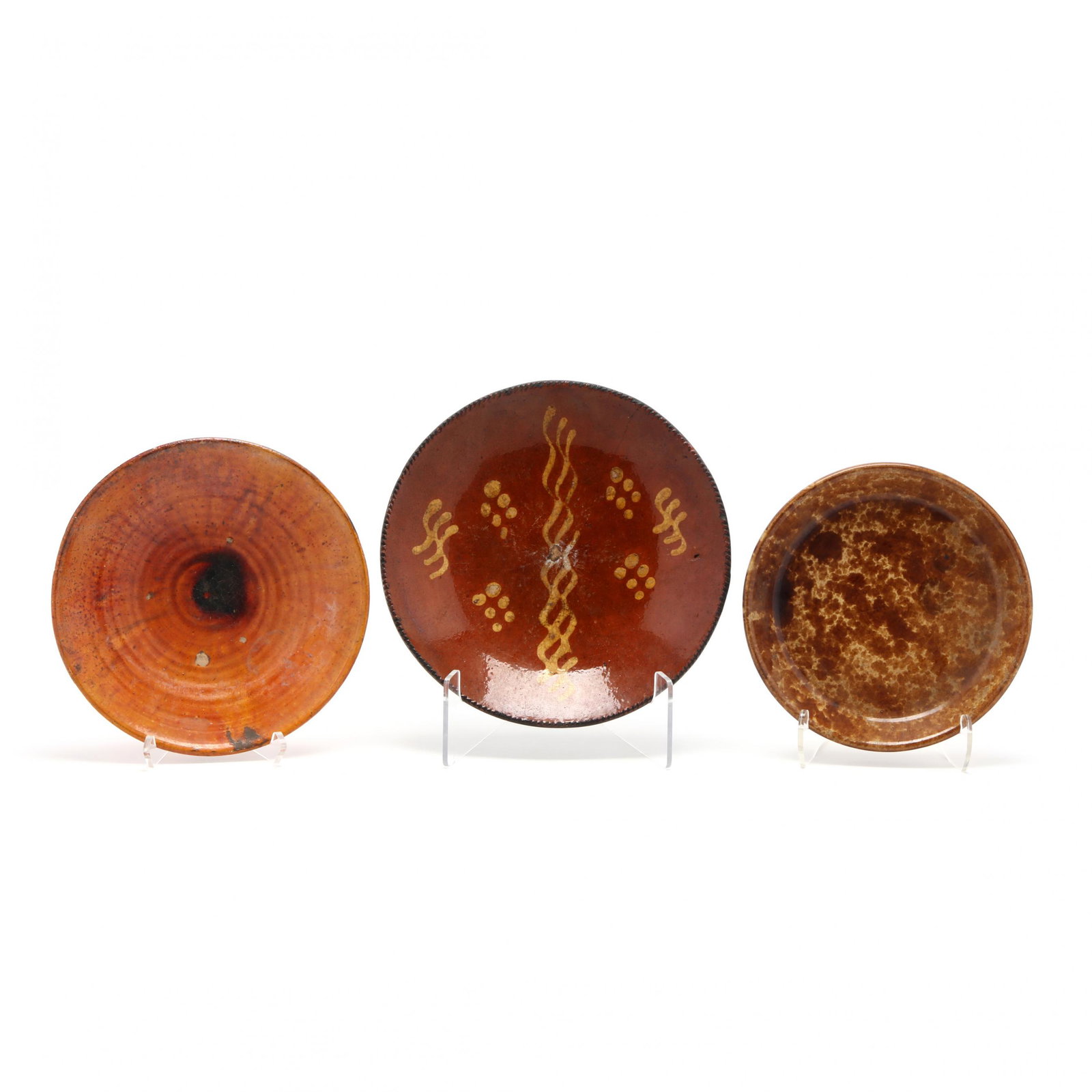Three Earthenware Pottery Dishes: Three Earthenware Pottery Dishes a Chrome Red glazed bowl (crazing; glaze bubble losses) (2 x 10.25 in.); a brown spatterware pie dish (1.25 x 9.25 in.) a slip decorated dish with crimped edge (loss t