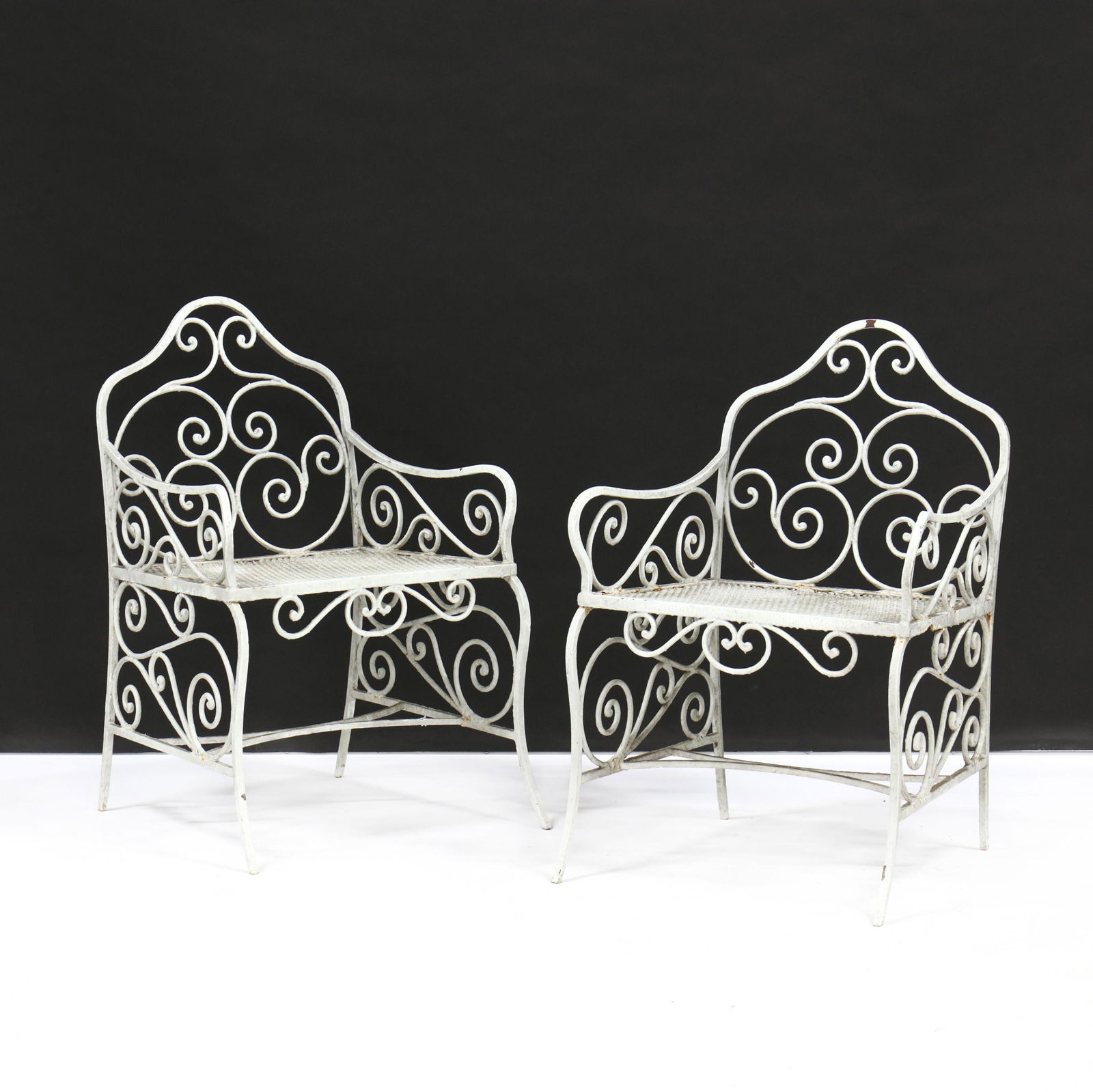 Vintage Pair of Iron Garden Chairs: Vintage Pair of Iron Garden Chairsmid 20th century, white paint, wide seat arm chairs with scrolled decoration. 35 x 23 x 18 in. Additional high-resolution photos are available at LelandLittle.com
