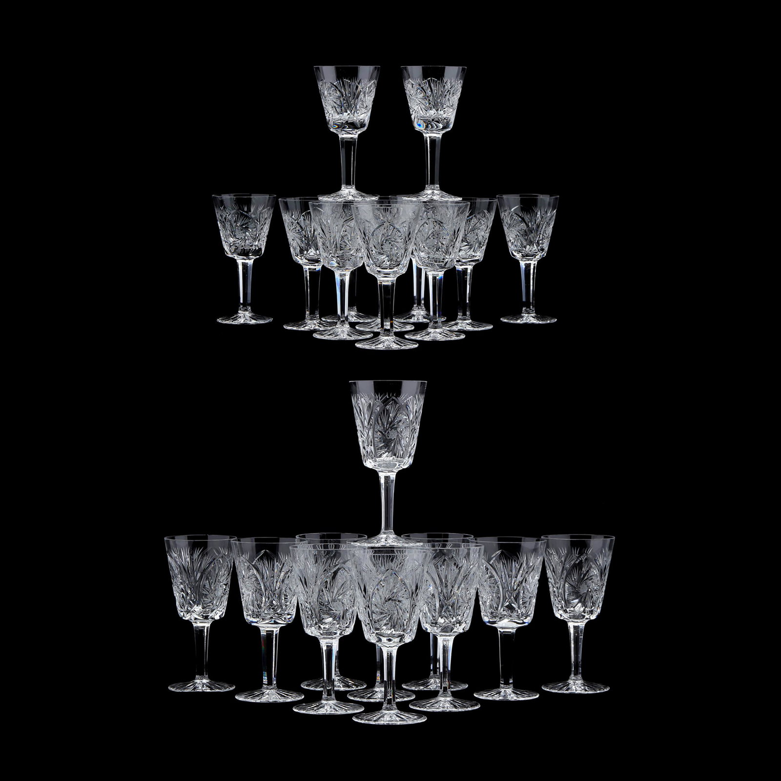 (23) Cut Glass Wine Stems: (23) Cut Glass Wine Stems late 20th century, wheel cut in a hobstar pattern, including (11) red wines (7 in.), and (12) white wines (5.5 in.), unmarked. From the Collection of James H. Craig and Randy