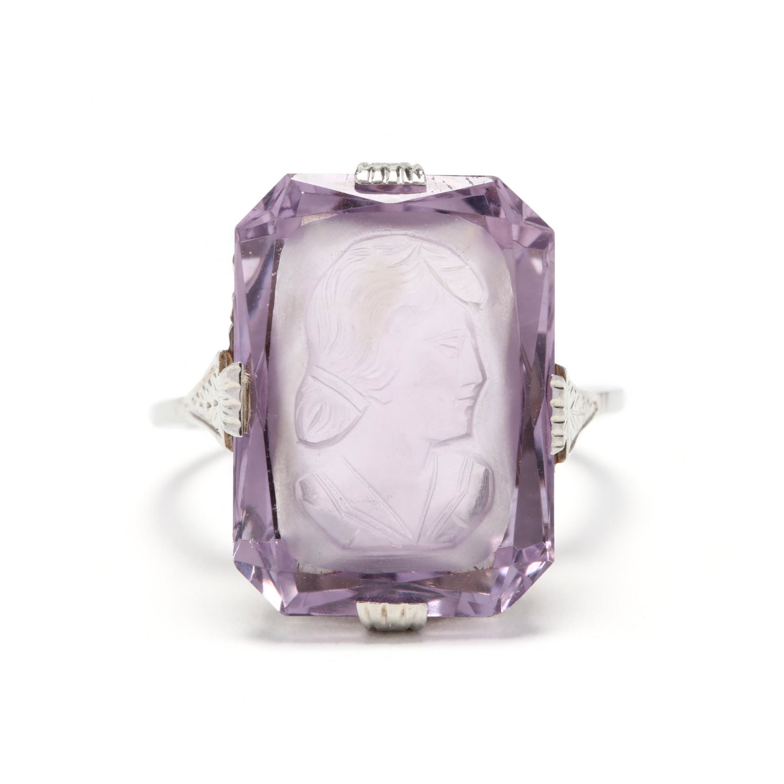 White Gold and Carved Amethyst Ring: White Gold and Carved Amethyst Ring the intaglio carved rectangular step cut amethyst (17.78 x 12.94 x 7.12mm) depicting a young woman, with open carved detailing to gallery and engraved accents to sh