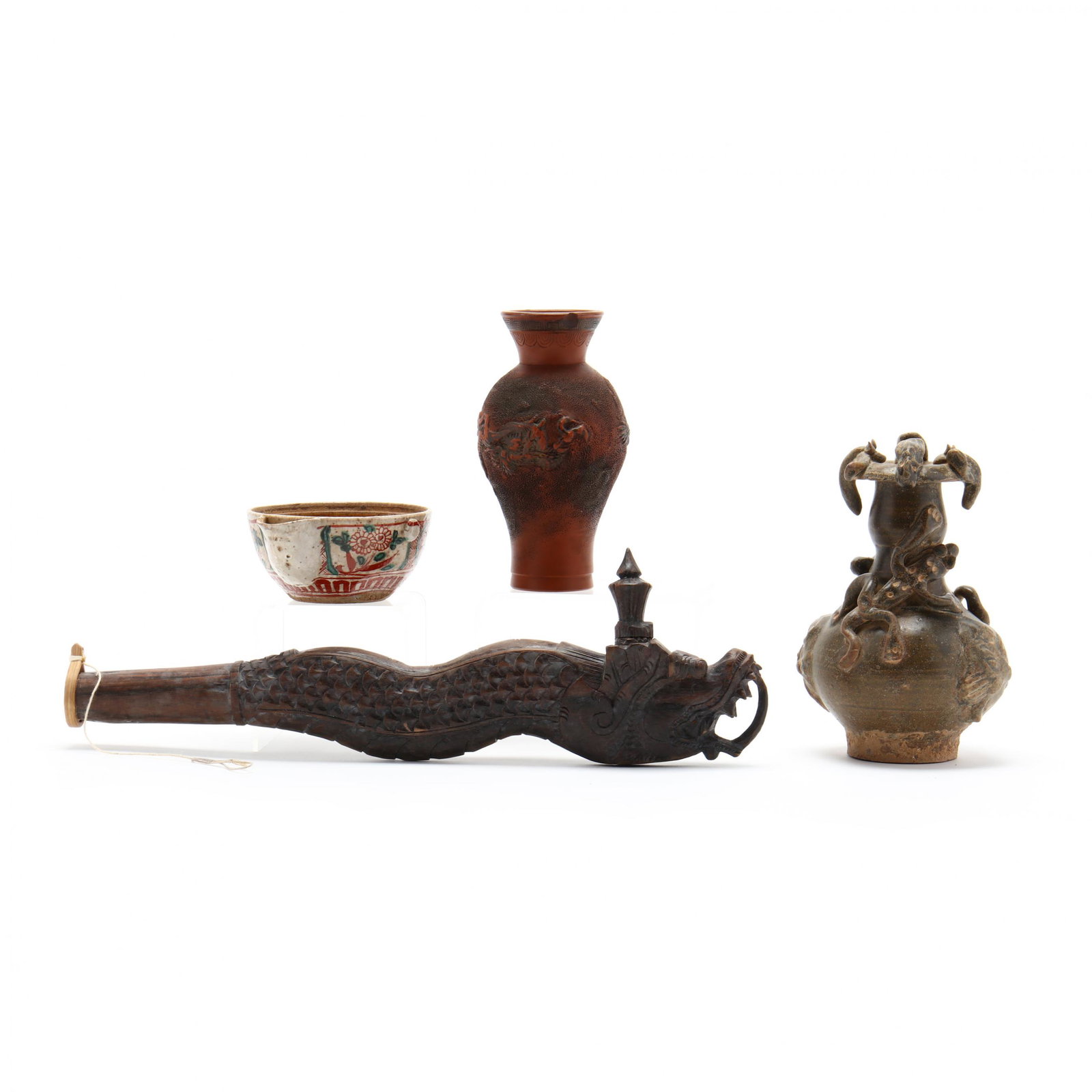 A Group of Four Asian Decorative Items: A Group of Four Asian Decorative Items includes a Southeast Asian, probably Indonesian, carved wooden dragon flute (14.25 in.), a small Japanese redware vase with raised decoration of a dragon (6 in.;