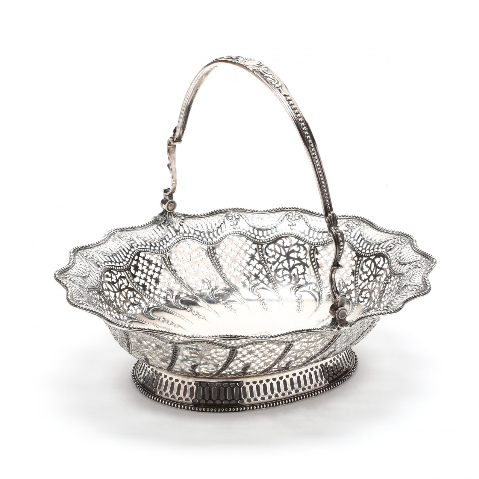George III Silver Cake Basket, Mark of William Plummer: George III Silver Cake Basket, Mark of William Plummer partial sponsor's mark, London (1777), exceptional decorative cutwork to basket, swing handle, shaped edge with beaded rim, period armorial engra