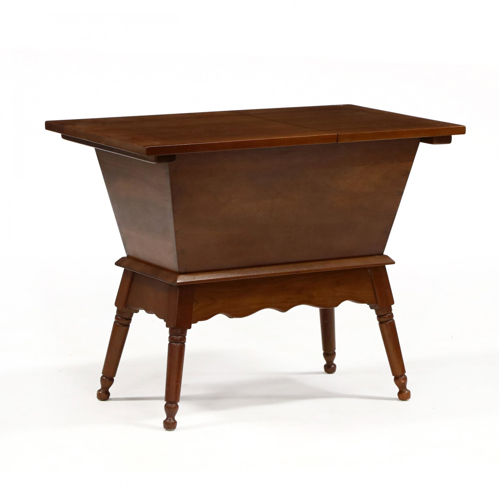 Leopold Stickley, Cherry Dough-Box Side Table: Leopold Stickley, Cherry Dough-Box Side Table 1950s, rectangular top with hinged lid, tapered box with scalloped skirt on turned legs, labeled. 25 x 31 x 19 in. Additional high-resolution photos are a