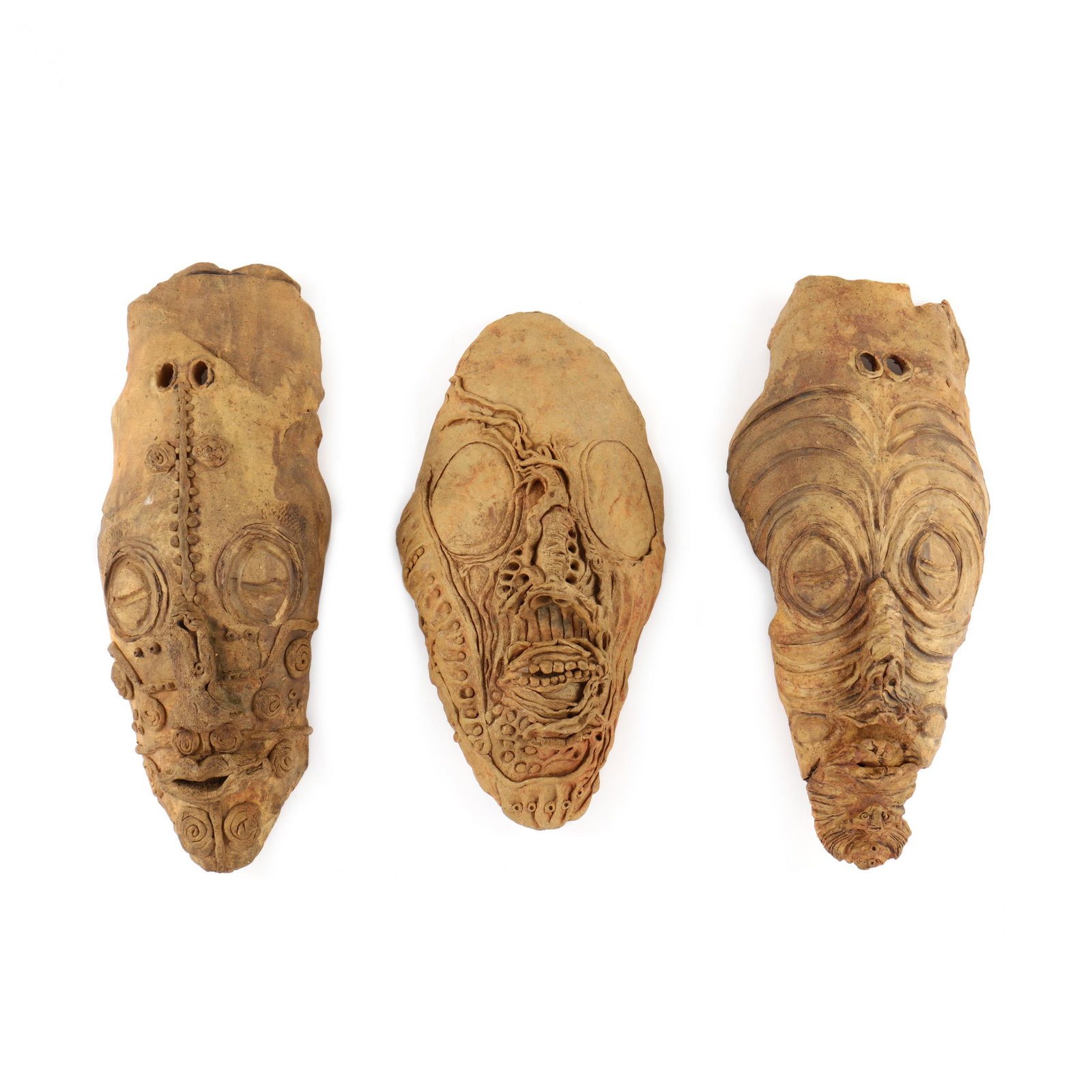 Three Studio Pottery Slab Masks: Three Studio Pottery Slab Masks contemporary, hand-formed, each with an earthenware dry finish with applied tribal decoration, appear unmarked. Tallest 20.5 in. Each a contemporary version of ancient 