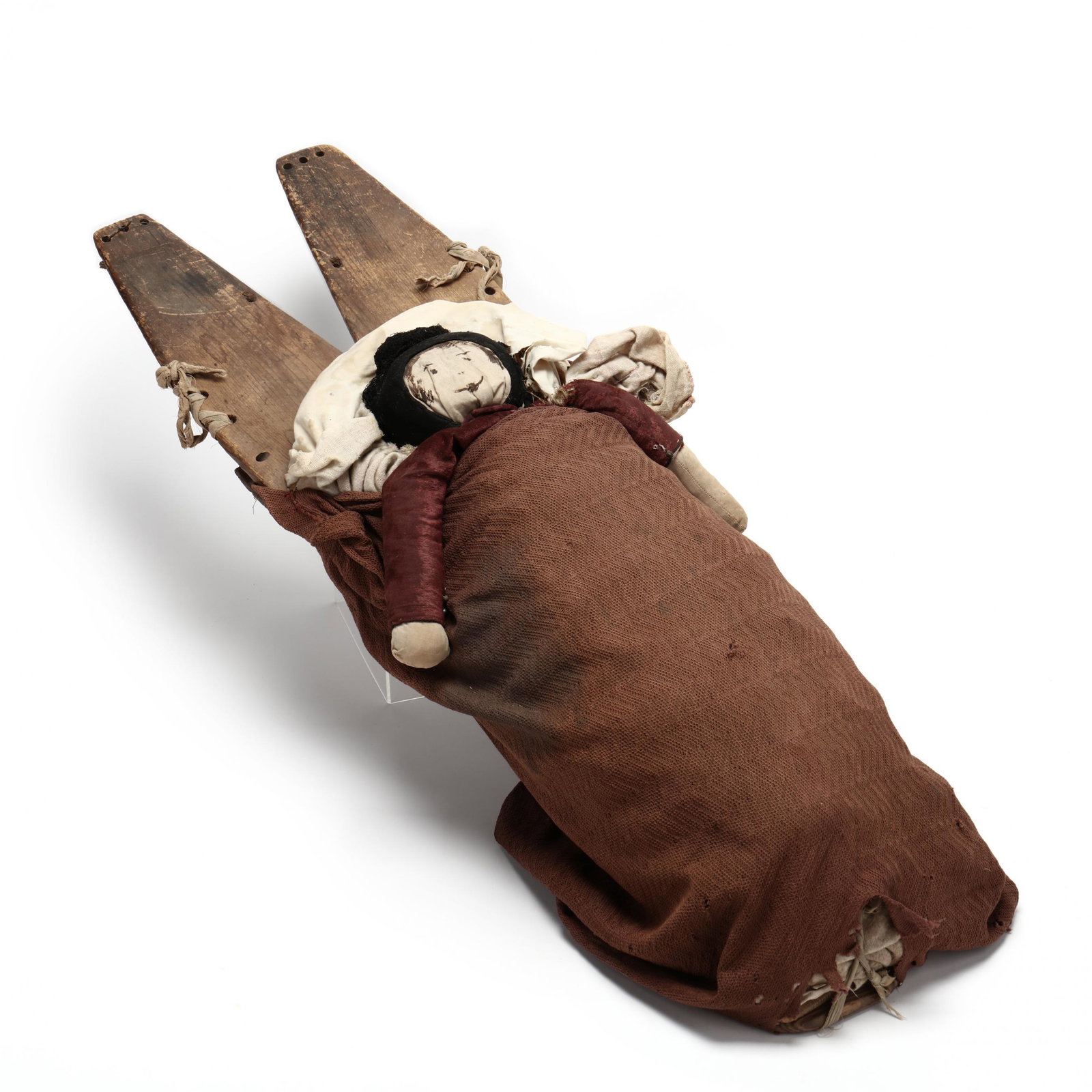 Vintage Life-Size Navajo Wooden Cradle Board and Doll: Vintage Life-Size Navajo Wooden Cradle Board and Doll 1920s or earlier, the doll with hand-drawn features and wearing a silk blouse, the whole swathed in a somewhat coarse cotton fabric. 35 in. From t