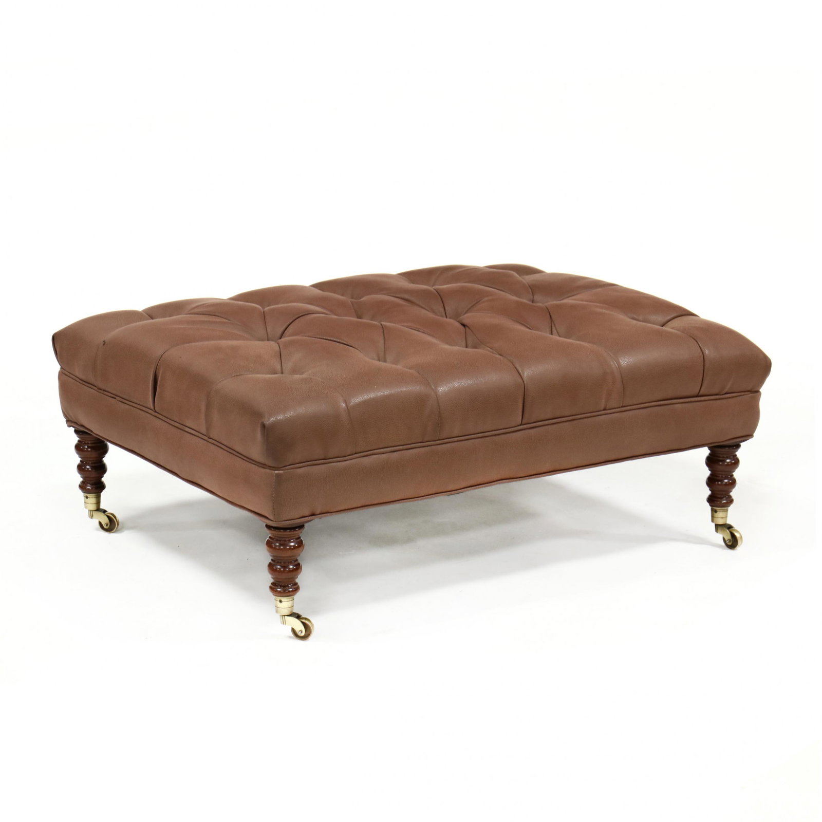 English Style Tufted Leather Ottoman / Coffee Table: English Style Tufted Leather Ottoman / Coffee Tablelate 20th century, brown tufted leather raised on turned mahogany legs with brass casters, labeled A. Chambers Upholstery. 15 x 40 x 29 in. From the