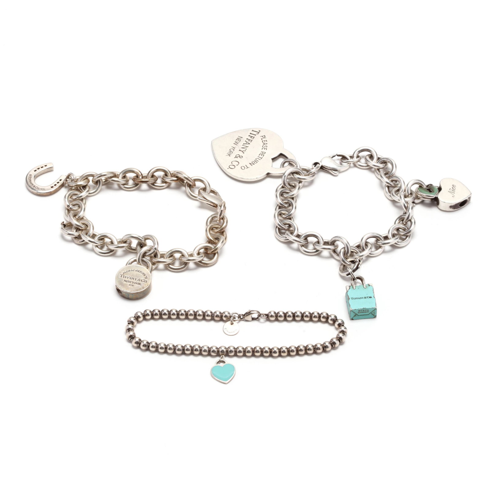 Three Sterling Silver Bracelets, Tiffany & Co: Three Sterling Silver Bracelets, Tiffany & Co to include: a ball bead bracelet with a blue enamel heart charm (stamped Tiffany & Co / 925; 7.5 in.); a rolo link bracelet with a large heart charm, a he