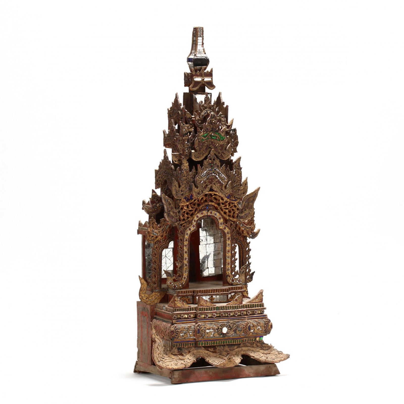A Burmese Carved Wooden Buddhist Shrine: A Burmese Carved Wooden Buddhist Shrine 19th century, lacquered and gilded wood with mirror and colored glass inlay, traces of red and green paint, in three parts, with a mirrored throne area for a Bu