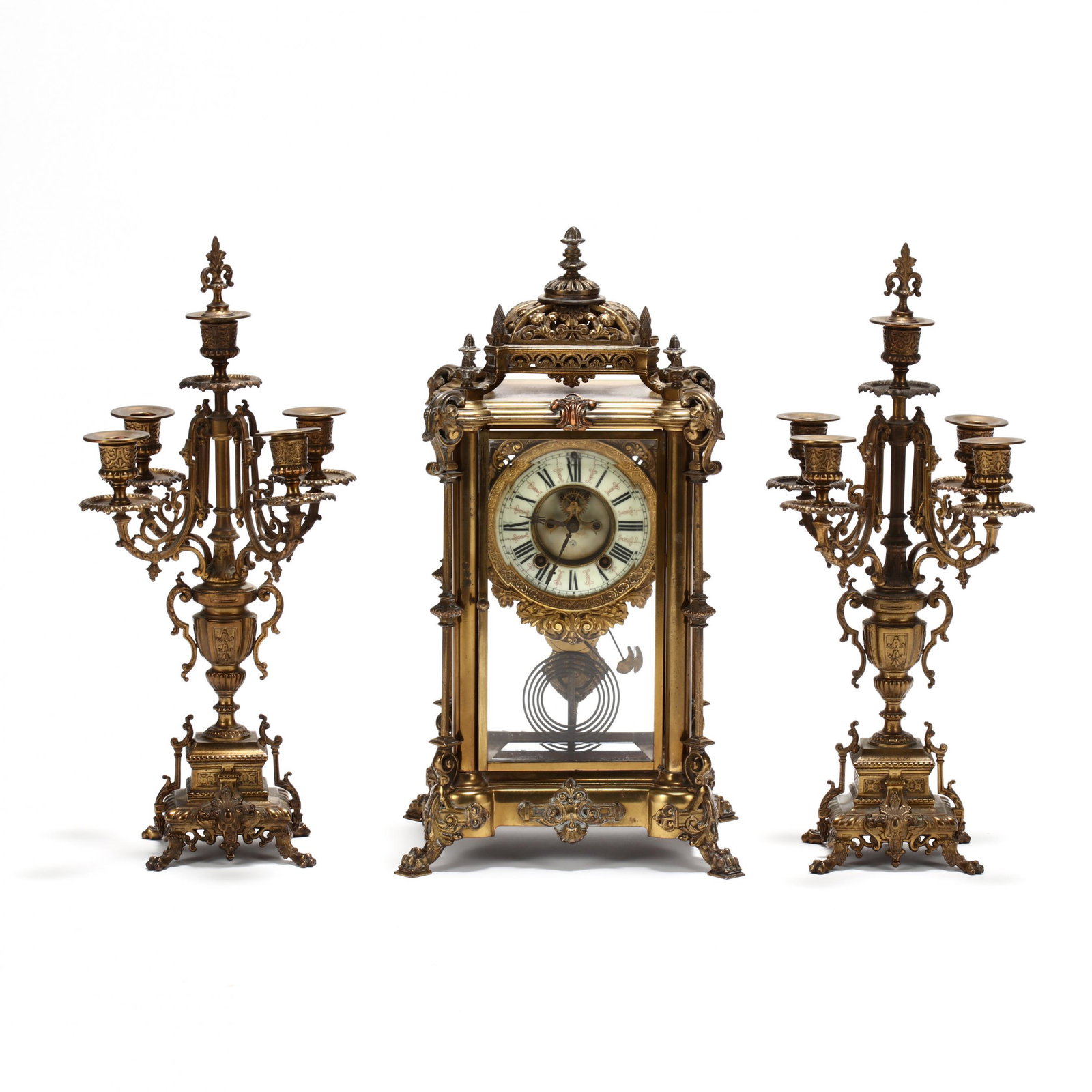 Ornate Ansonia Mantel Clock Garniture Set: Ornate Ansonia Mantel Clock Garniture Set time and strike brass movement, open escapement porcelain dial with Roman numerals and the Ansonia trade mark, the beveled glass door and sides set into an or