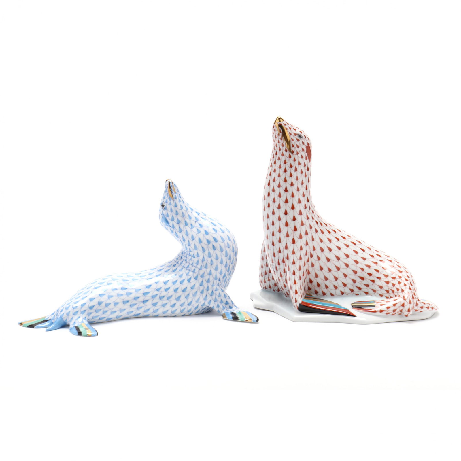 Herend Porcelain Large Sea Lions: Herend Porcelain Large Sea Lions A rust fishnet #5223 posed on an 'ice fragment' (7 1/8 in.) and a blue fishnet figure with arched neck (5 1/8 x 8 in.) From the Collection of George & Lou Harris, Mart