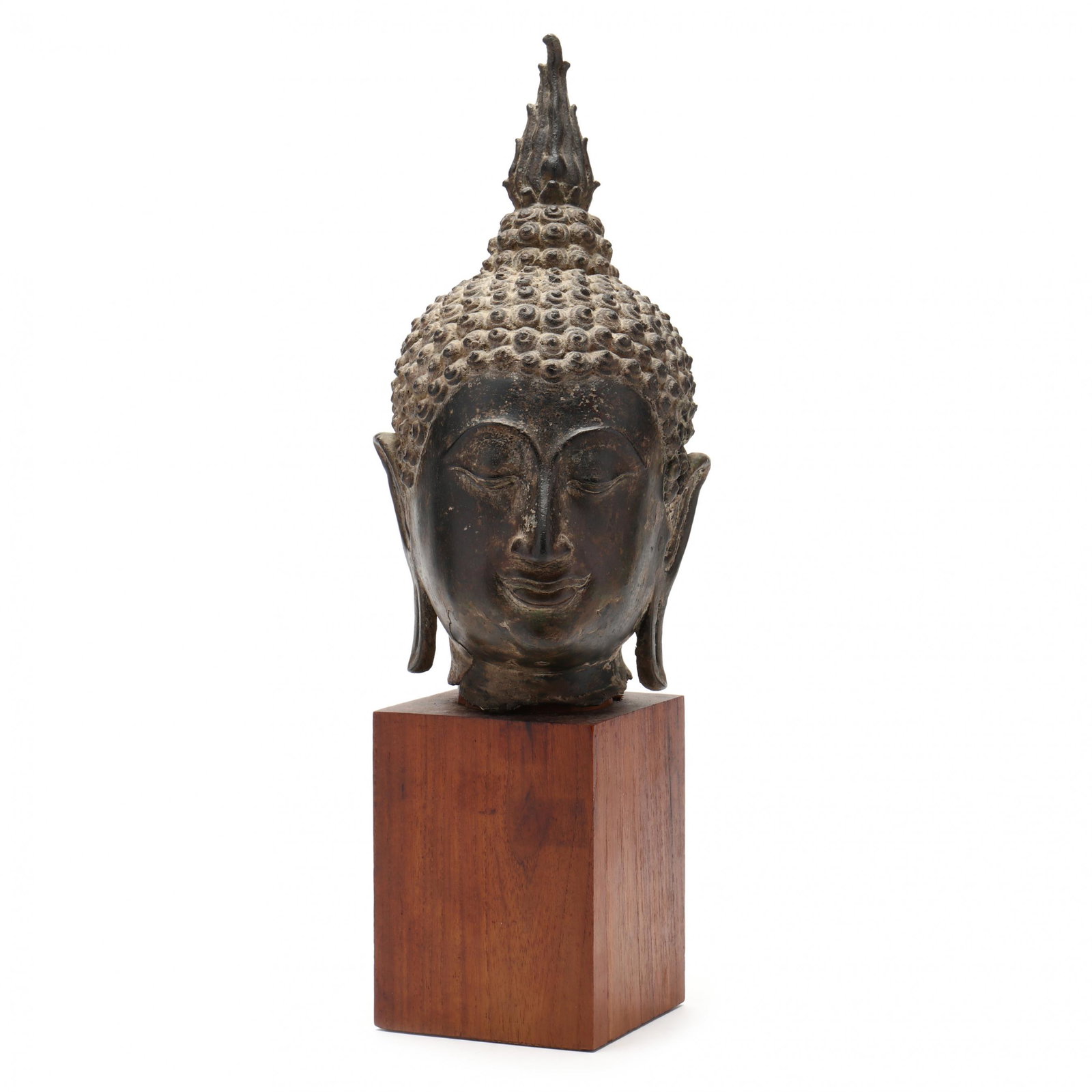 A Thai Bronze Head of Buddha: A Thai Bronze Head of Buddha antique, finely cast in the Sukhothai period style, mounted in a wooden pedestal, purchased in Bangkok at Thai Antiquarium in 1967, comes together with Certificate of Anti
