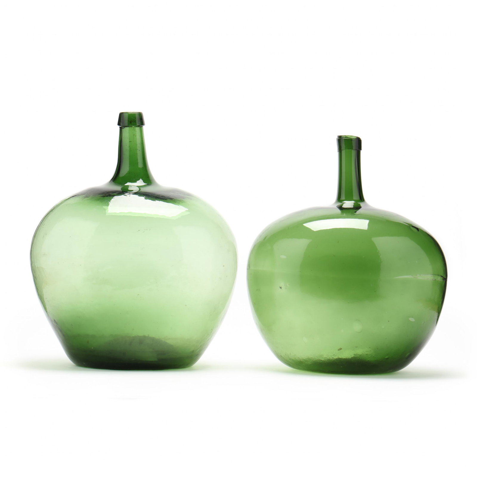 Two Large Green Glass Demijohn Storage Bottles: Two Large Green Glass Demijohn Storage Bottlescontemporary, likely Continental, onion form with long necks. 18.5 in. and 17.25 in. From the Personal Collection of Bob Timberlake, Lexington, North Caro