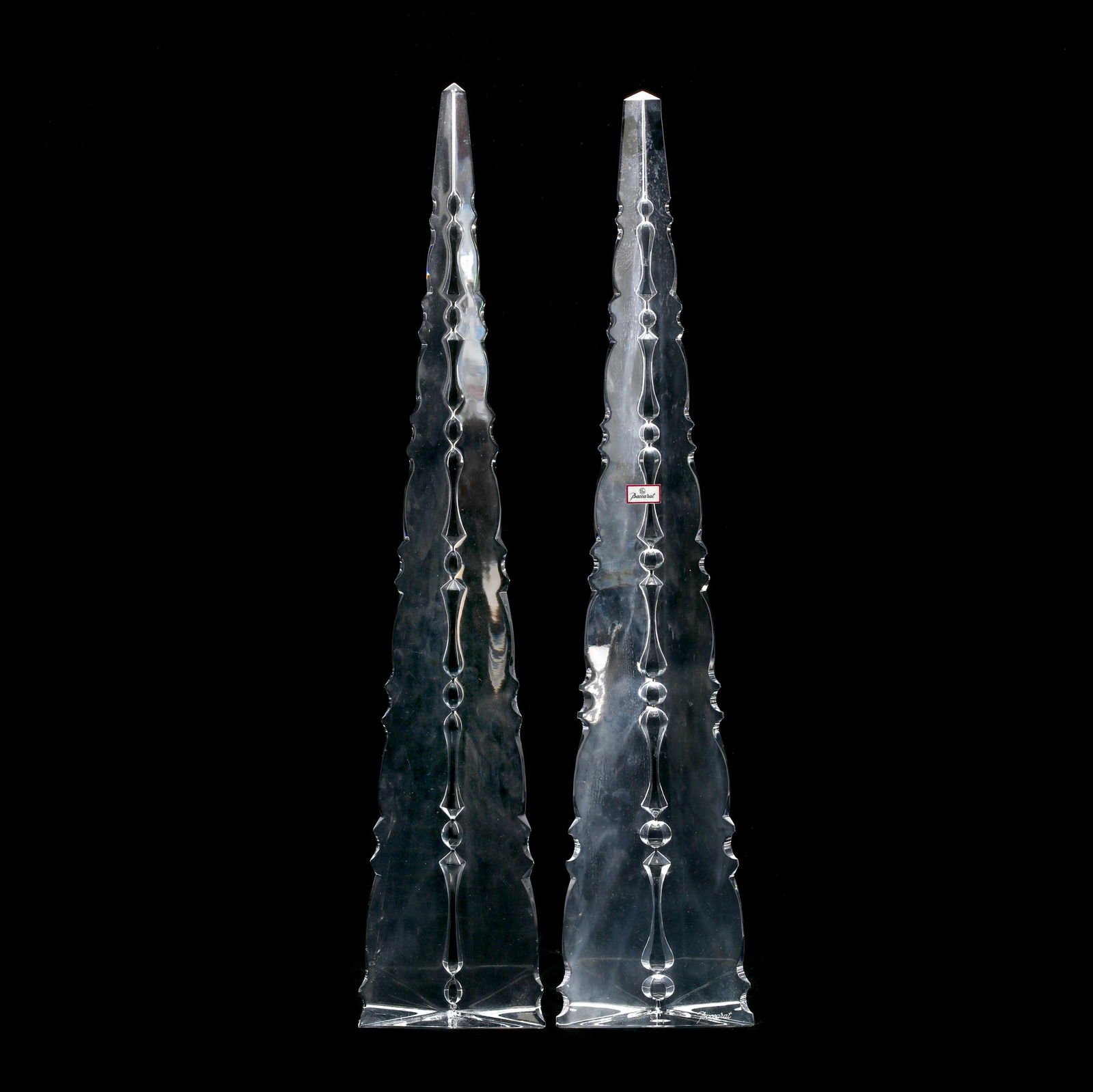Baccarat, Near Pair of Scalloped Crystal Obelisks: Baccarat, Near Pair of Scalloped Crystal ObelisksFrance, tall tapered form with scalloped edges causing a prismatic effect when viewed straight on, signed. 18 in. The Collection of Mr. Duggins and Mr.