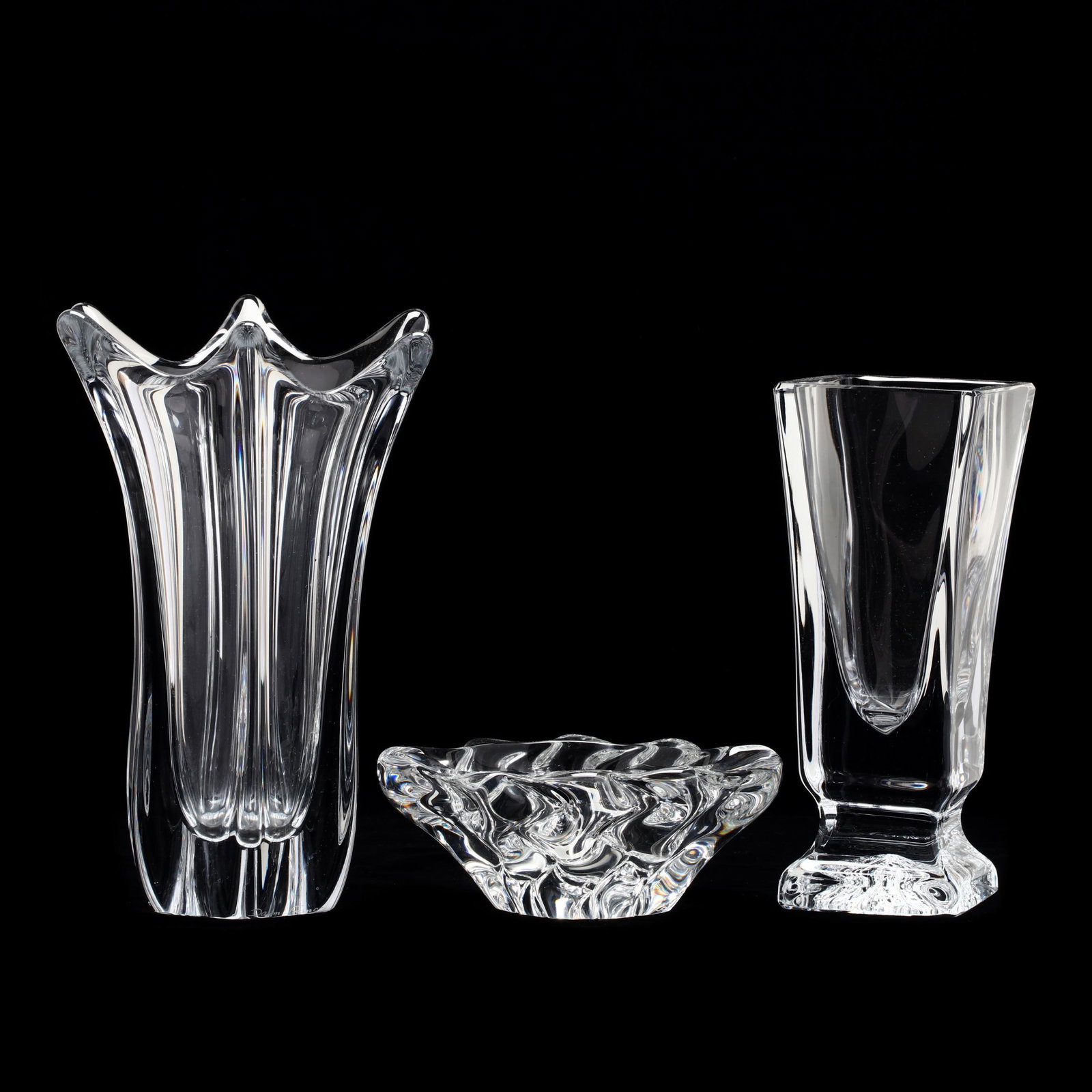 Daum, Three Pieces of Crystal: Daum, Three Pieces of Crystal France, including a thick clear scalloped rim vase, a tapered block form vase with impressed design foot, and a thick crystal ashtray, signed. Tallest 9.75 in. The Collec
