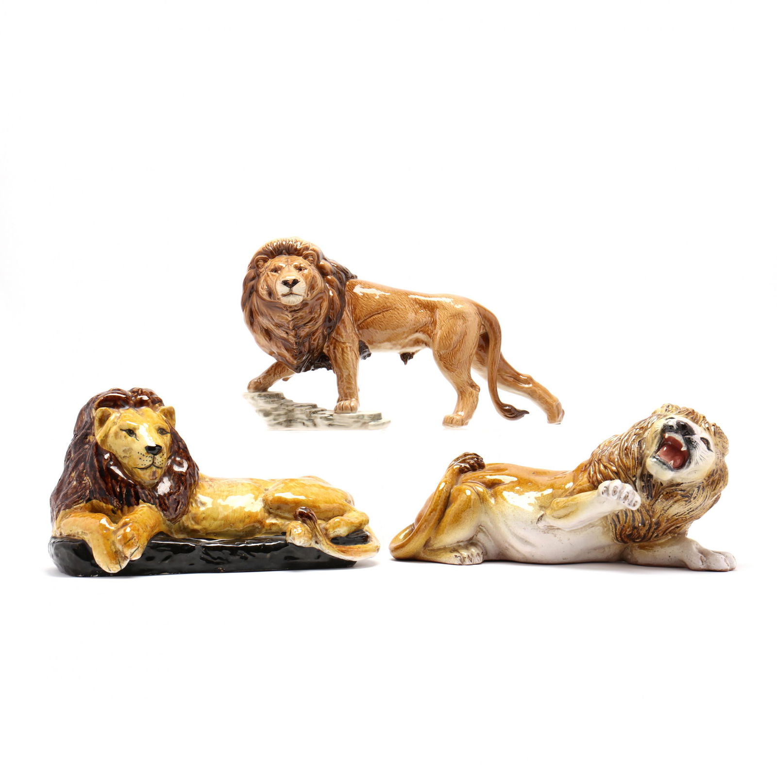Three Differing Ceramic Lions: Three Differing Ceramic Lionsa majolica recumbent lion, probably Italy (9.5 x 15.5 in.) (small flaking of black near base); a marked Goebel W. Germany standing lion (10.25 x 17 in.) (good condition);
