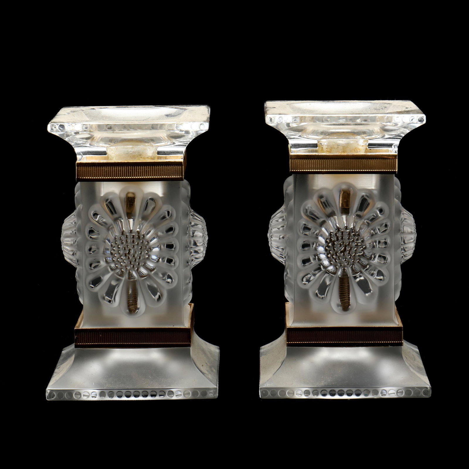 Lalique, Pair of Parquettes Candlesticks: Lalique, Pair of Parquettes Candlesticks France, clear polished and frosted crystal with raised flower design and match-strike ormolu trim, signed. 5.25 x 2.75 x 2.75 in. The Collection of Mr. Duggins