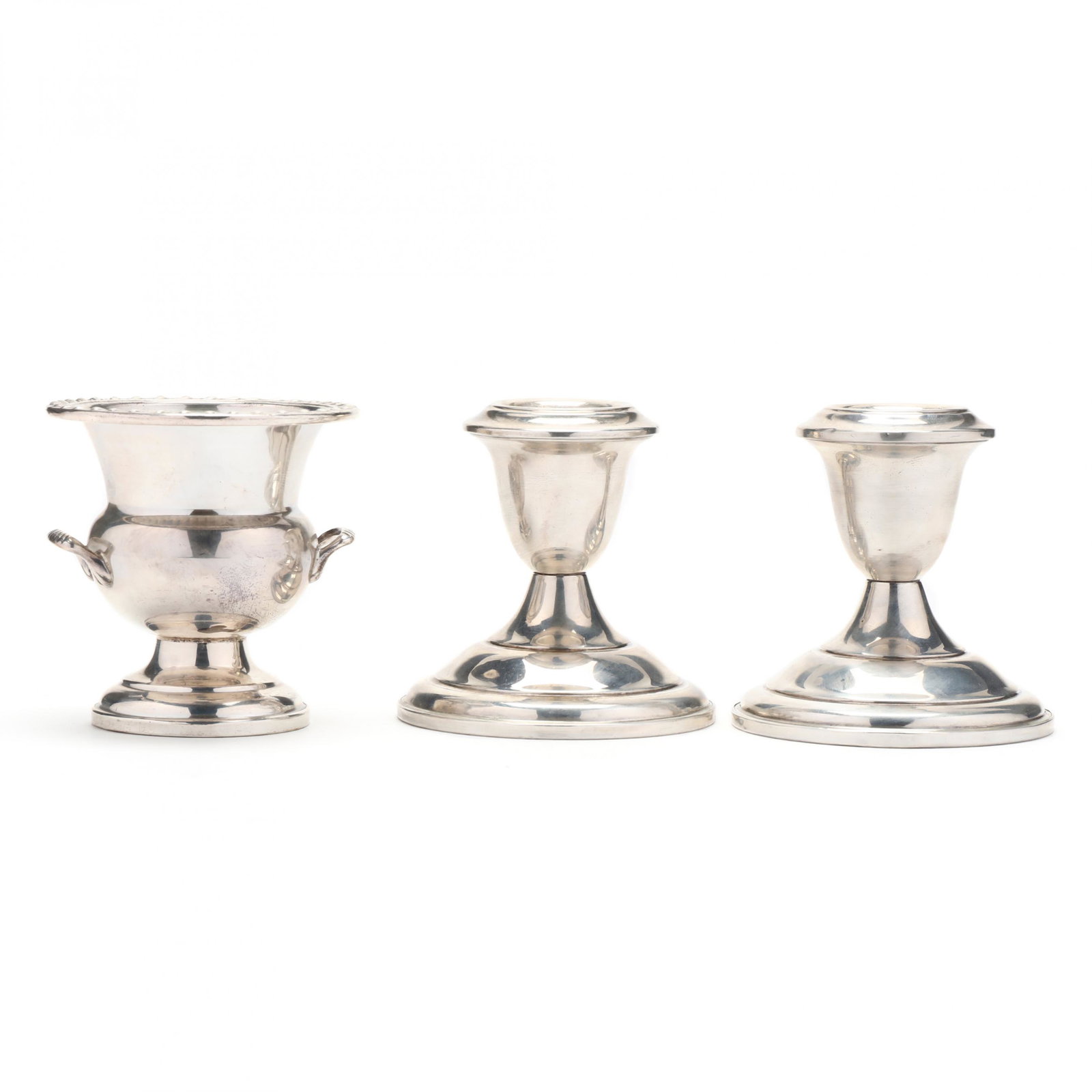 A Grouping of Three Sterling Silver Table Accessories: A Grouping of Three Sterling Silver Table Accessoriesto include: first a pair of low candlesticks, weighted, without hallmarks (HOA 2.75 in.) (both with small dents to base rim); second a cigarette ur