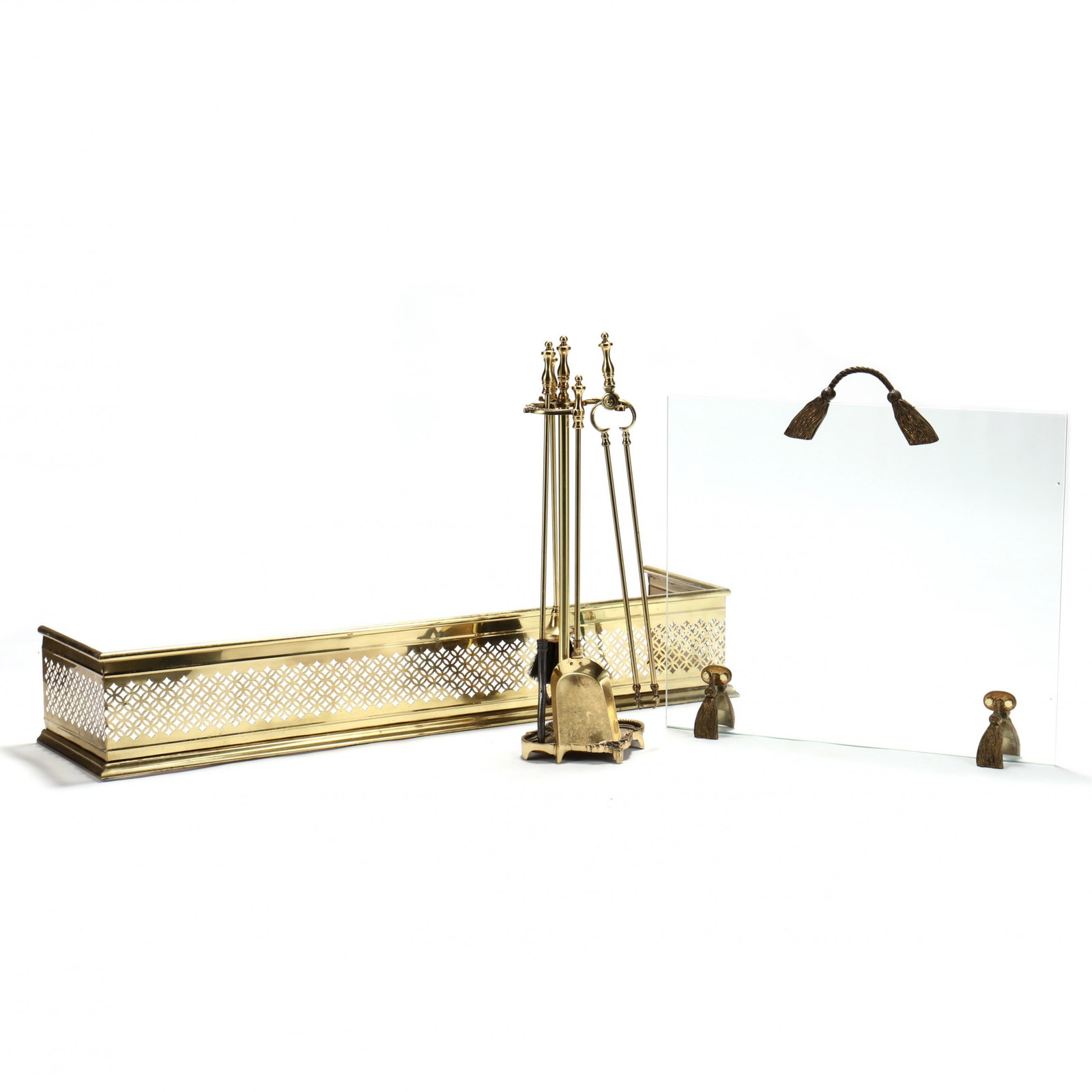 Brass Fireplace Grouping: Brass Fireplace Grouping late 20th century including a pierced brass fire fender (8.5 x 48.5 x 12.5 in.), glass and brass fire screen with tassel accents (26.5 x 27.5 x 4 in.); and a Rococo style tool