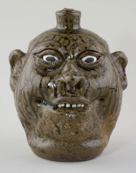 Georgia Folk Pottery Lanier Meaders Face Jug,: well patterned drippy alkaline glaze, applied features including a single row of slightly protruding clay teeth, signed in script on the bottom. 9"
