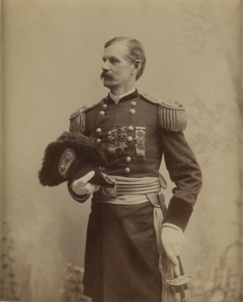 Postwar Albumen Portrait of Union Cavalry General,: ca. 1880, the subject wears full dress uniform with chapeau and white gloves, cavalry badges on his breast flank a GAR medal with single star on hanger. The officer's left sleeve is wrapped in a mourn