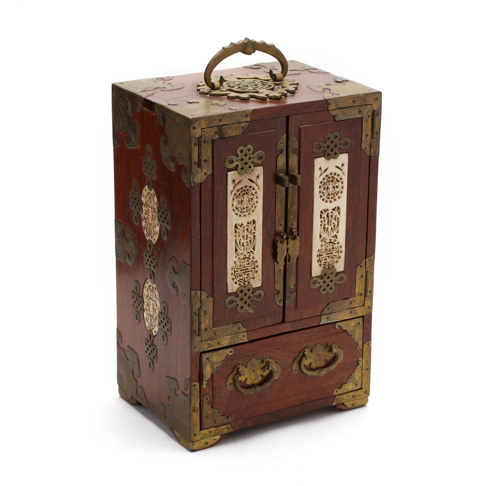 An Antique Asian Jewelry Chest: An Antique Asian Jewelry Chest early 20th century, hardwood with ornate brass mounts, brass ring handle finial, centered reticulated bone inlay to sides and front doors, opening to four drawers with r