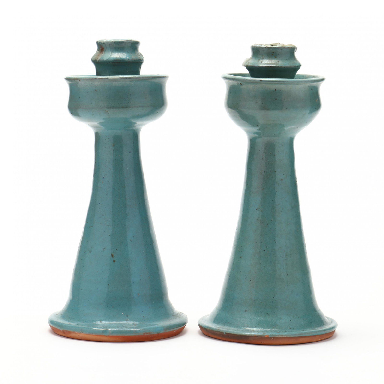 NC Pottery, Billy Ray Hussey, Pair of Candlesticks: NC Pottery, Billy Ray Hussey, Pair of Candlesticksearthenware with aqua glaze, typical Seagrove form, with deep cups and wide bases, inscribed on the underside "BH". 10 7/8 in. From the Collection of