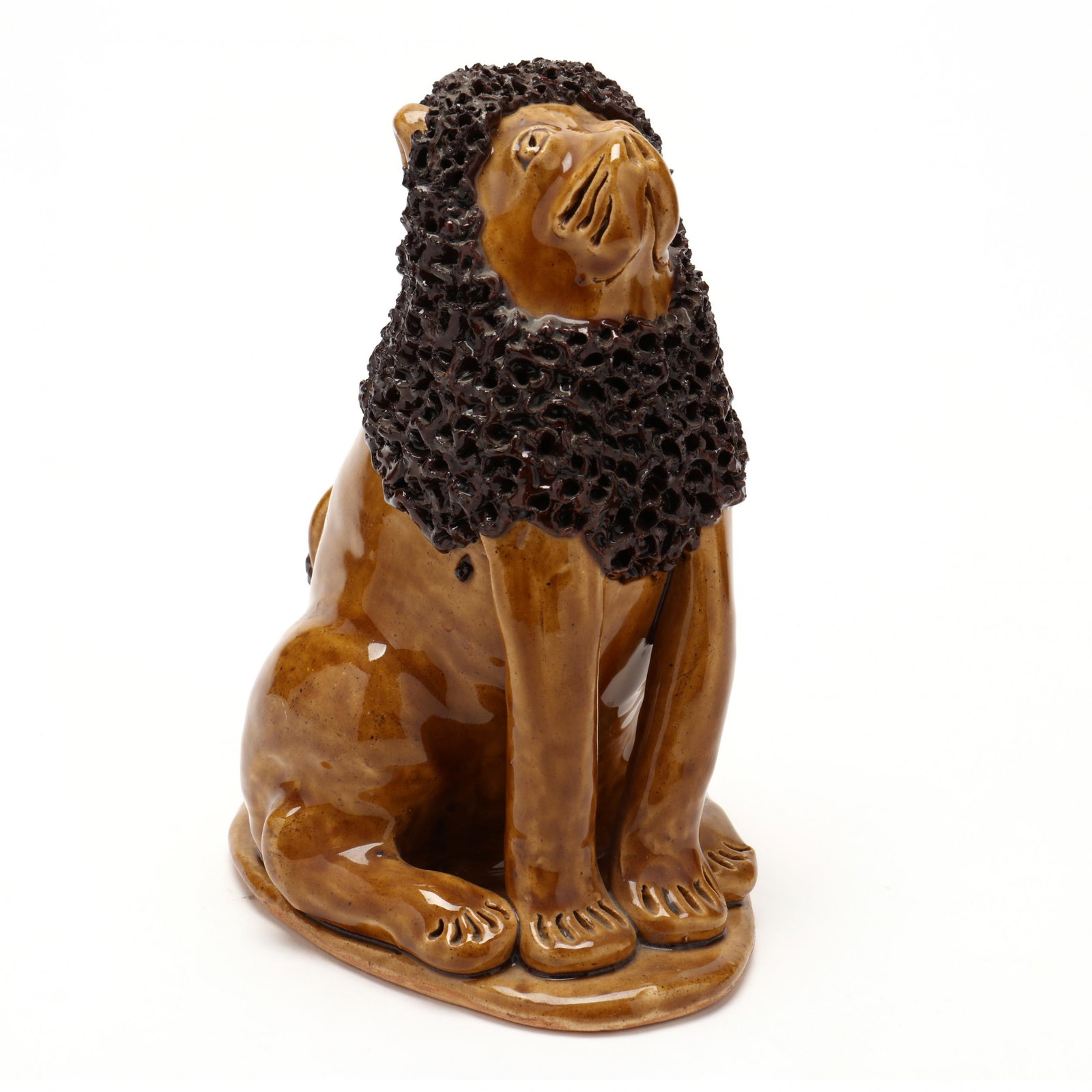 NC Folk Pottery, Billy Ray Hussey, Seated Lion: NC Folk Pottery, Billy Ray Hussey, Seated Lion clear glazed earthenware with brown curly mane, seated on a shaped platform base, inscribed on the underside "BH". 7.5 x 5.5 in. From the Collection of t