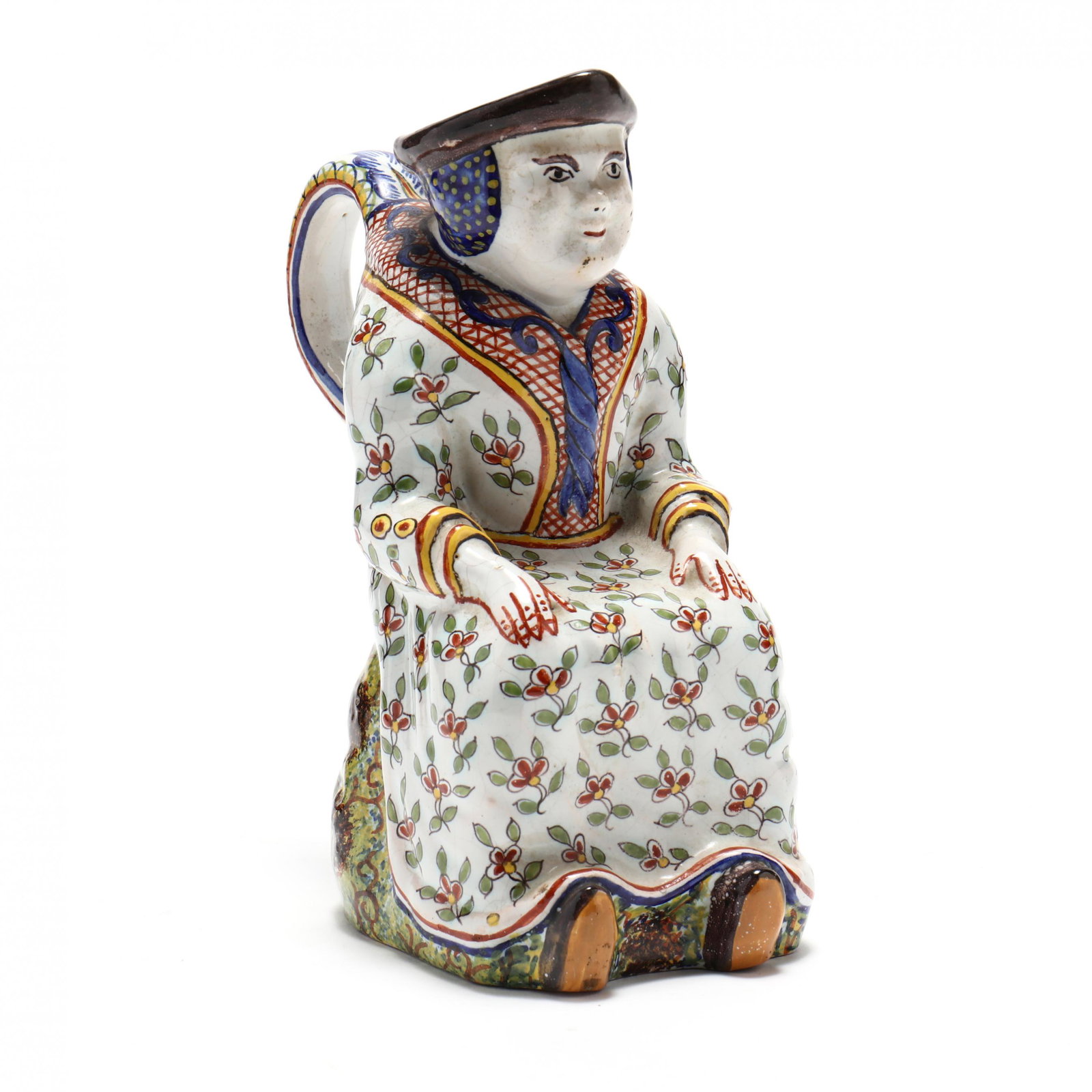 French Faience Figural Jug: French Faience Figural Jug the unglazed underside with the 17th century unidentified mark "F.C", possibly Marseilles, in the form of a woman seated upon a grassy mound, polychrome painted with a flora
