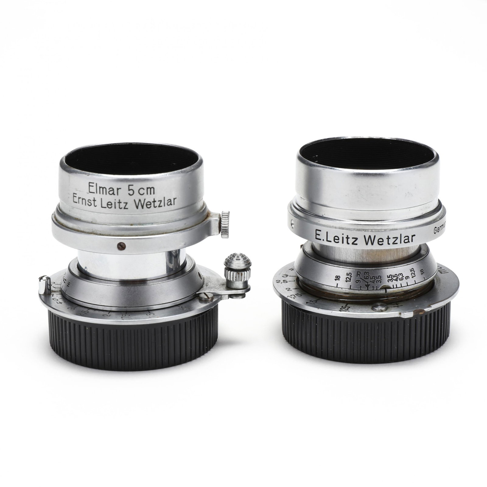Pair of Leica Leitz Elmar MTR f=5cm 1:3,5 Lens: Pair of Leica Leitz Elmar MTR f=5cm 1:3,5 Lens Germany, No.'s 427620 and 612583, each with E. Leitz Wetzlar Elmar 5cm lens hood, without lens caps. 1 3/4 x 2 in. Private Collection of a Gentleman, Gre
