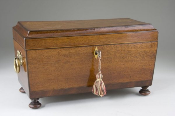 English Tea Caddy, 19th century: English Tea Caddy, 19th century sarcophagus form on turned feet, mahogany veneers conservatively outlined with lightwood inlaid trim, ivory keyhole escutcheon, brass ring handles on either side, inter