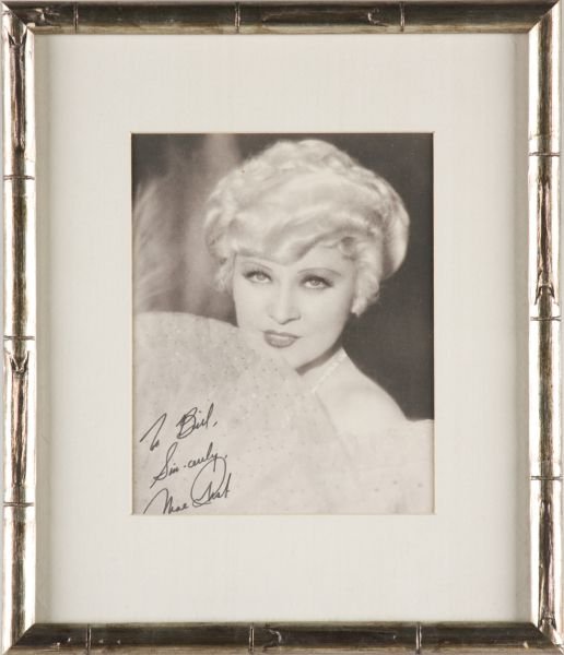 Mae West Inscribed Photograph: Mae West Inscribed Photograph "To Bill / Sincerely, / Mae West", matted in silvered wooden frame. SS 8.25 x 6.5 in.; DOA 14 x 12 in. The Bill Morrison Collection of Film & Stage Memorabilia