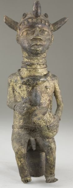 West African Gilt Bronze Statuette, Benin: West African Gilt Bronze Statuette, Benin depicts a seated man wearing a ceremonial headdress while beating a drum. 13.25 in. Private deceased estate collection, Chapel Hill, NC.