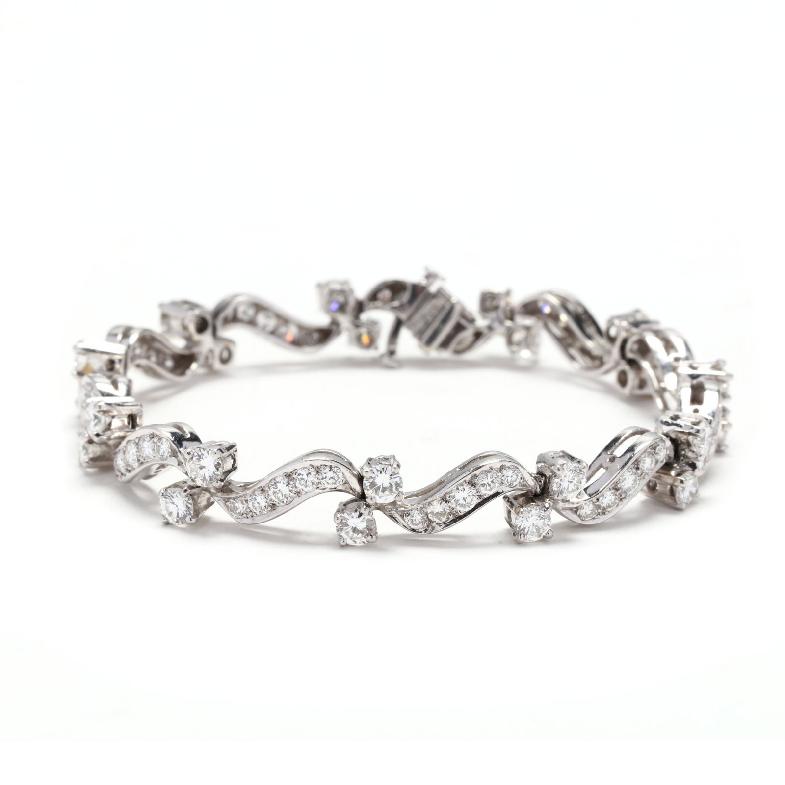 Platinum and Diamond Bracelet: Platinum and Diamond Bracelet bracelet comprised of stylized curved links bead set with full cut round diamonds and alternating with prong set full cut round diamonds, completed with an integrated cla
