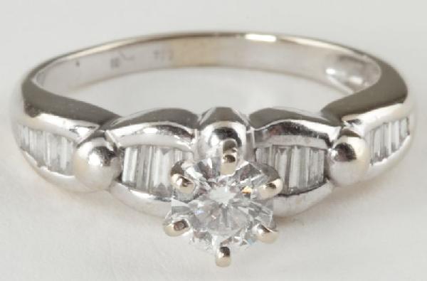 Diamond Solitaire Ring: Diamond Solitaire Ring centering on one round brilliant cut diamond, flanked on either side by tapering rows of baguette cut diamonds; the center diamond weighs approximately .47 carat and the accent 