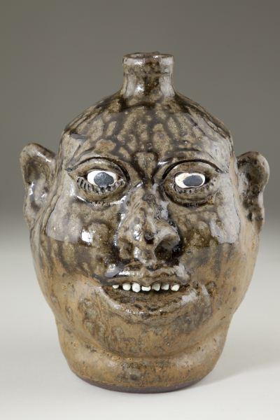 GA Folk Pottery, Lanier Meaders Face Jug: GA Folk Pottery, Lanier Meaders Face Jug open mouth with upper teeth, inset eyes, signed on the base "Lanier Meaders." 9.75 in. Over-fired alkaline glaze.