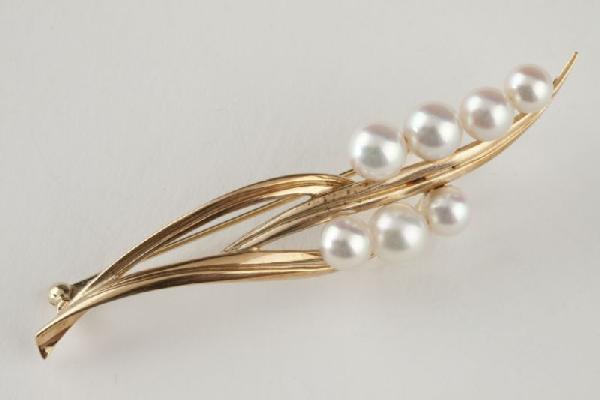Akoya Cultured Pearl Brooch, Mikimoto: Akoya Cultured Pearl Brooch, Mikimoto mid to late 20th century, designed as a stylized gold leaf set with 7 6.5mm round cultured akoya pearls with good luster and slightly pink overtones, mounted in 1
