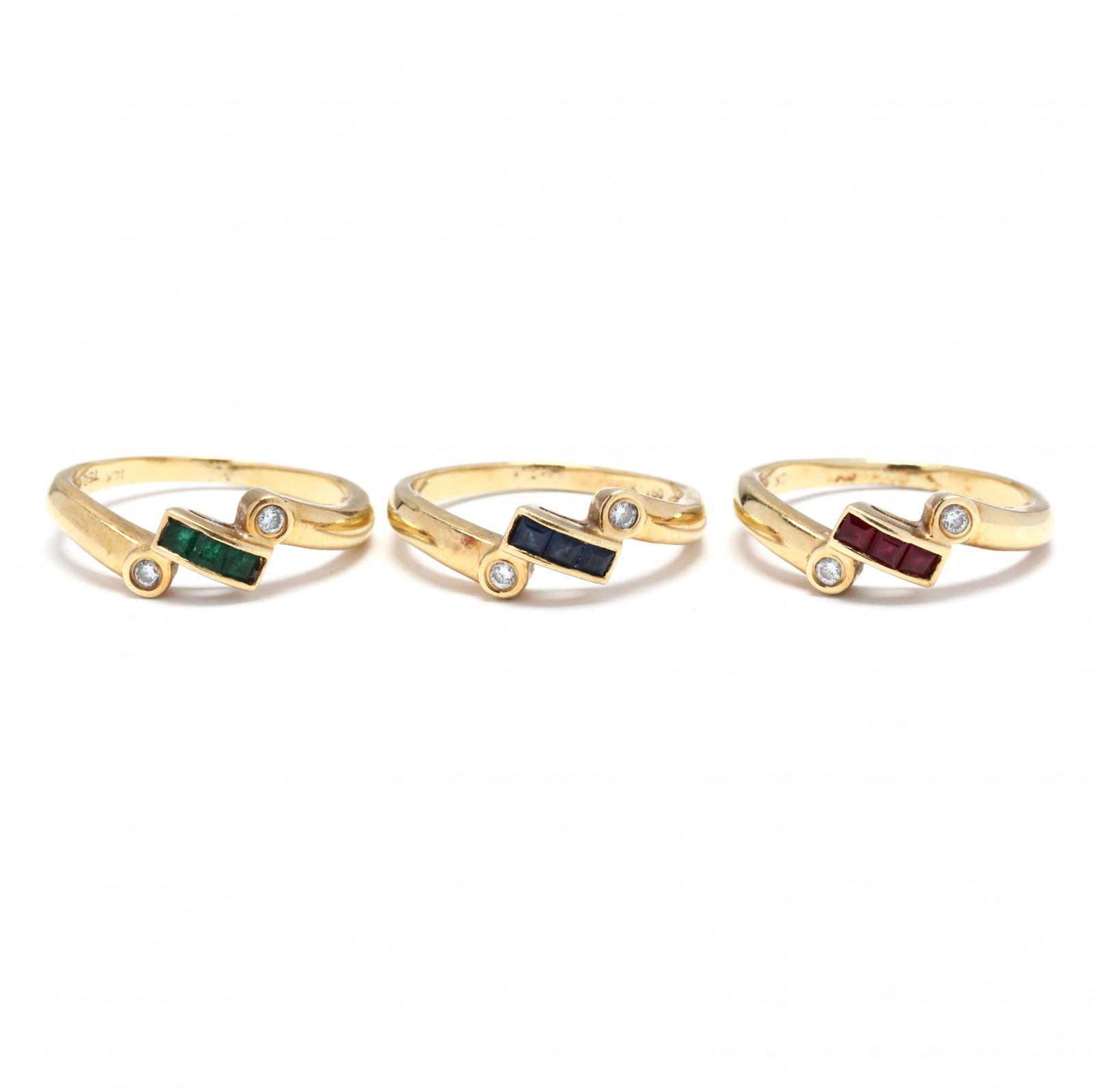 Gold and Gem-Set Stackable Rings: Gold and Gem-Set Stackable Ringsin a crossover and stackable design, one with channel set square cut emeralds, one with rubies, and one with sapphires and with bezel set full cut round diamond melee (