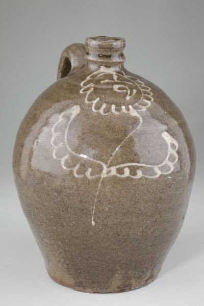 Edgefield SC Jug, Collins Rhodes Factory: Edgefield SC Jug, Collins Rhodes Factory circa 1840's, alkaline glazed stoneware jug with kaolin slip decoration, gallon capacity "1/2" surrounded by slip decorated cartouche resembling flower head, w