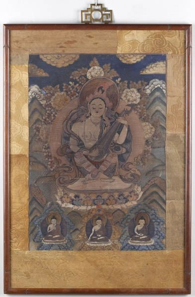 Antique Buddhist Thangka: Antique Buddhist Thangka paint on fabric with brocade surround, an old typed label on the back claims the dominant figure to be Mo-li Hai, guardian of the West. Presented behind glass in a vintage woo
