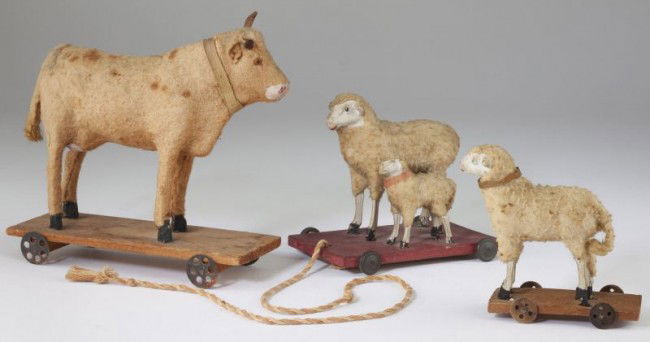 Group of Three German Pull Toys: Group of Three German Pull Toys circa 1890s, composition with "stick" legs, the sheep with lamb (4.25 in.) on a wood platform with metal wheels retains old braided pull, the single sheep (3.75 in.) st